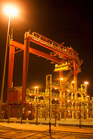 Cranes and ladders in shipyard at nightの写真素材