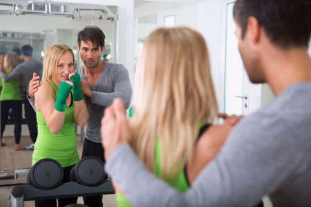 Boxer practicing with trainer in gym