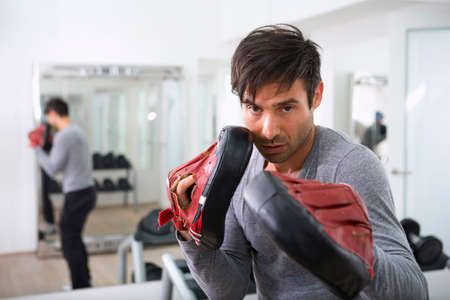 Trainer wearing padded gloves in gym