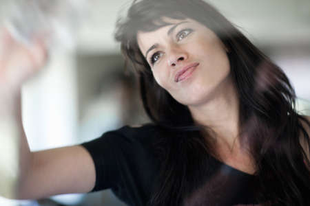 Smiling businesswoman wiping window