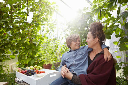 Mother and son sitting outdoorsの写真素材