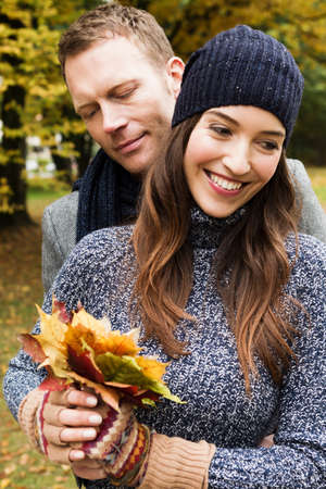 Couple holding autumn leavesの写真素材