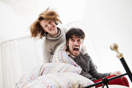 Smiling couple playing in bedの写真素材