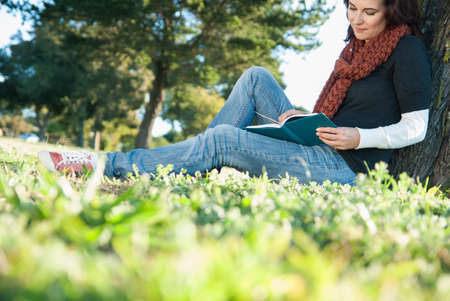 Woman reading book in grassの写真素材