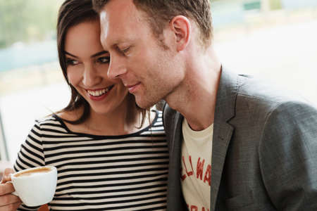 Smiling couple hugging in cafe