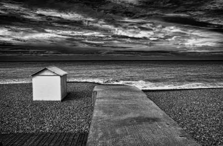 Concrete dock and hut on rocky beachの写真素材