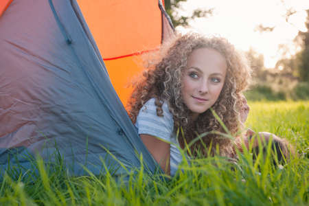 Teenage girl laying in tent at campsiteの写真素材