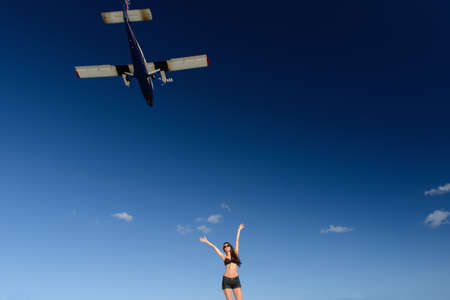 Woman in bikini greeting airplane