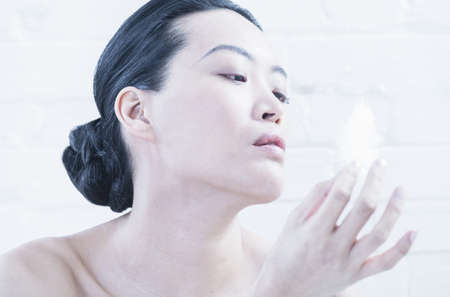 Nude woman examining featherの写真素材