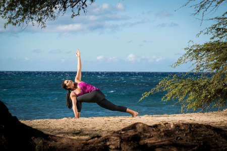 Woman practicing yoga on beach