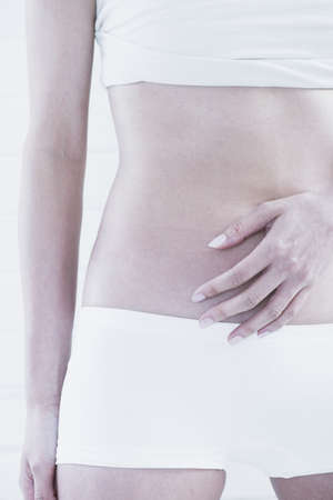 Woman?s hand covering her bellyの写真素材
