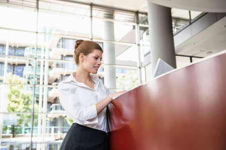 Business woman using laptop on reception deskの写真素材