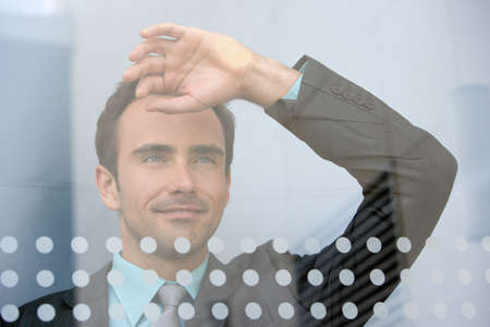 Businessman looking through windowの写真素材
