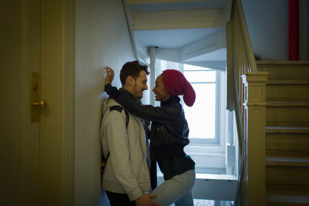 Young couple hugging in hallwayの写真素材