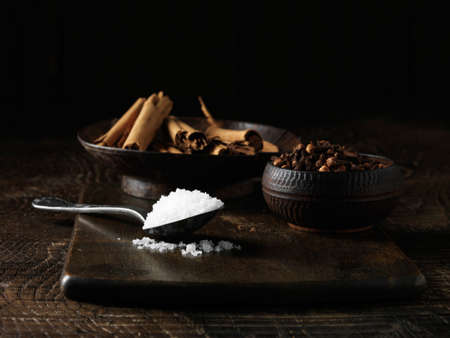 Ingredients to make an Irish dry cured spiced beef joint. Sea salt, cinnamon sticks and mixed spices on dark wooden surfaceの写真素材