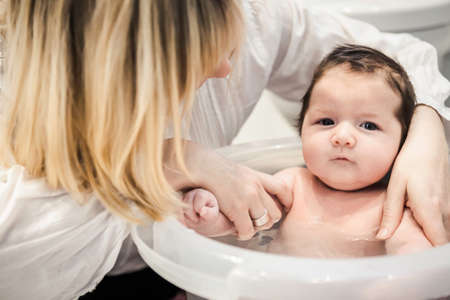 Mid adult mother bathing babyの写真素材