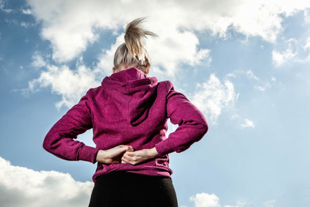 Young woman stretching with hands behind backの写真素材