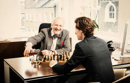 Two men playing chess in office