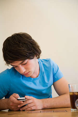 A teenage boy using a cell phoneの写真素材