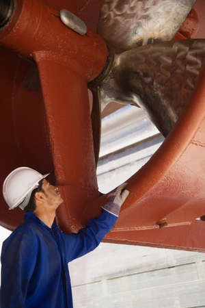 A worker looking at a ships propellerの写真素材
