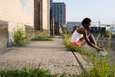 Runner sitting on sidewalk