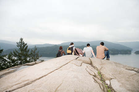 People on rock by a lakeの写真素材