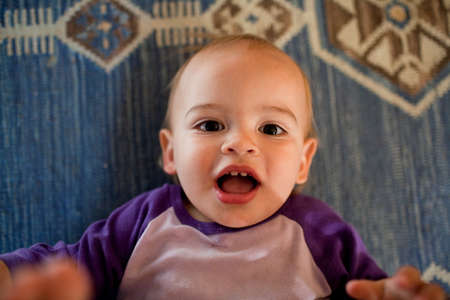 Baby boy lying on rug on floorの写真素材
