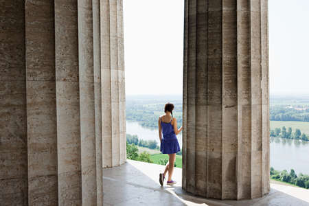 Woman by stone columns, Regensburg, Bavaria, Germanyの写真素材