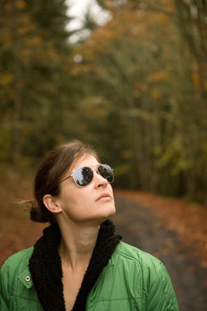 Woman wearing sunglasses looking upの写真素材