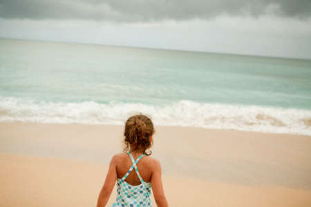 Young girl standing on sandy beachの写真素材