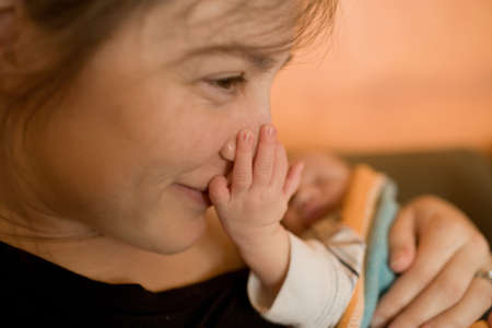 Mother with newborn son touching her faceの写真素材