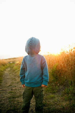 Boy wearing hooded top back to frontの写真素材