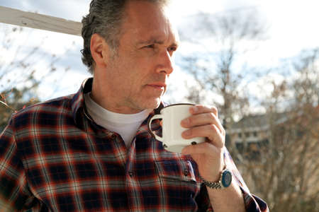 Mature man drinking from cup outsideの写真素材