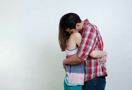 Young couple embracing, studio shotの写真素材