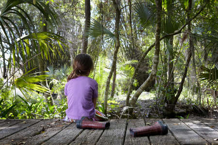 Girl sitting on boardwalkの写真素材