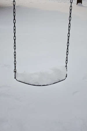 Snow covered swingの写真素材