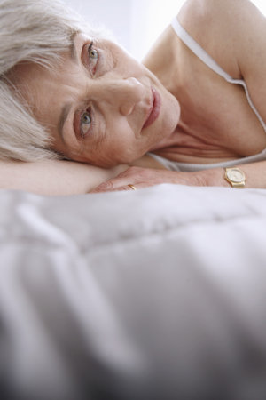 Senior woman relaxing on bedの写真素材
