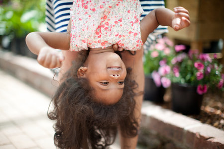 Mother holding daughter upside downの写真素材