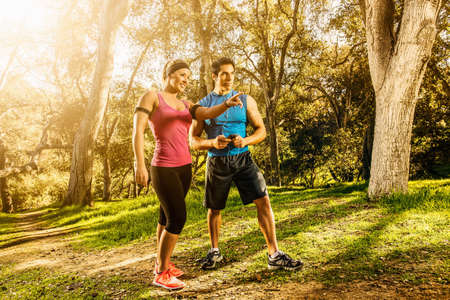 Two people exercising in forest deciding on direction