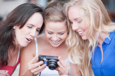 Three young women looking at photosの写真素材