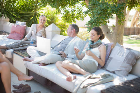 Casual business people on patio using laptopの写真素材