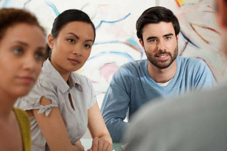 Young man and women in discussion in galleryの写真素材