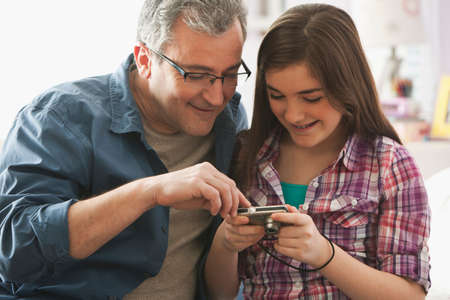 Mature man looking at digital camera with daughter