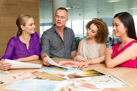 Fashion designers at desk looking at imageryの写真素材