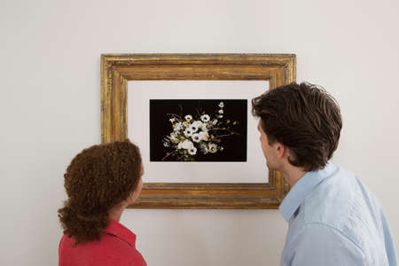 Young couple looking at print in picture frame