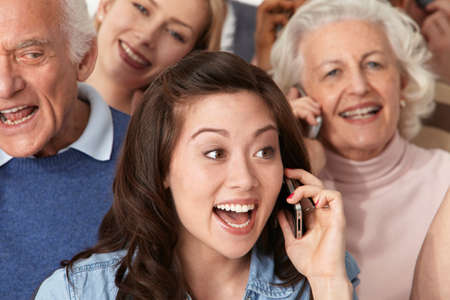 Woman on cell phone with group of peopleの写真素材