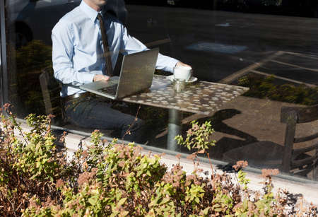 Businessman in cafe, view through windowの写真素材