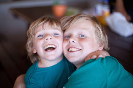 Smiling boys hugging in living room
