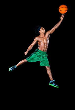 Basketball player leaping up with basketball