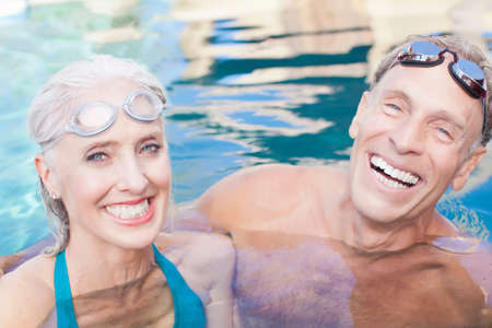 Older couple swimming in poolの写真素材